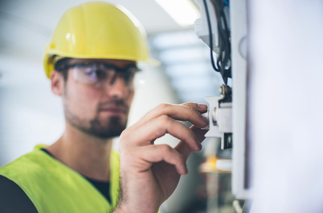 Construction worker altering a button