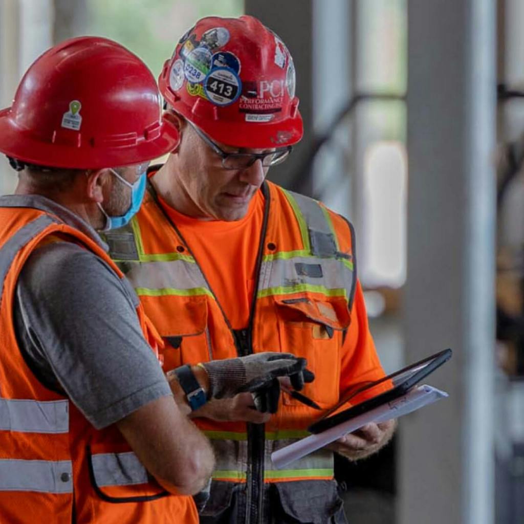Construction Workers collaborate over a mobile device