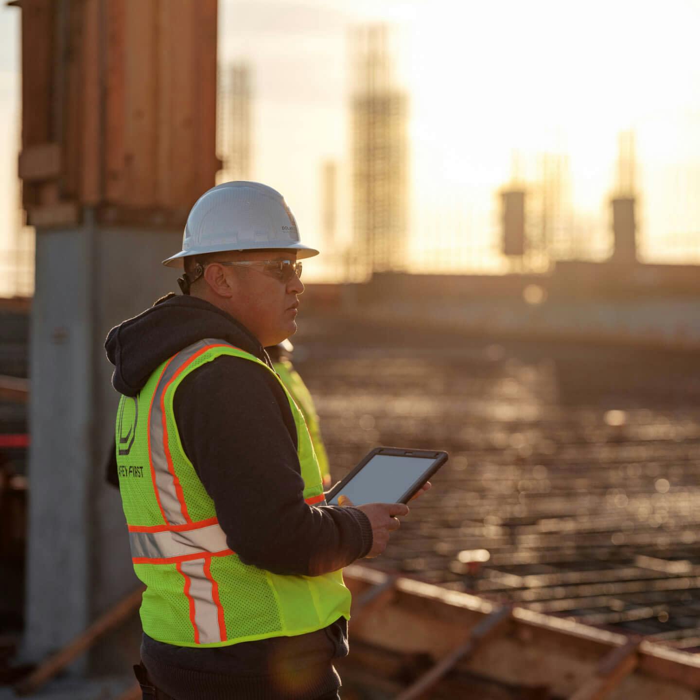 Construction worker using Procore on a tablet