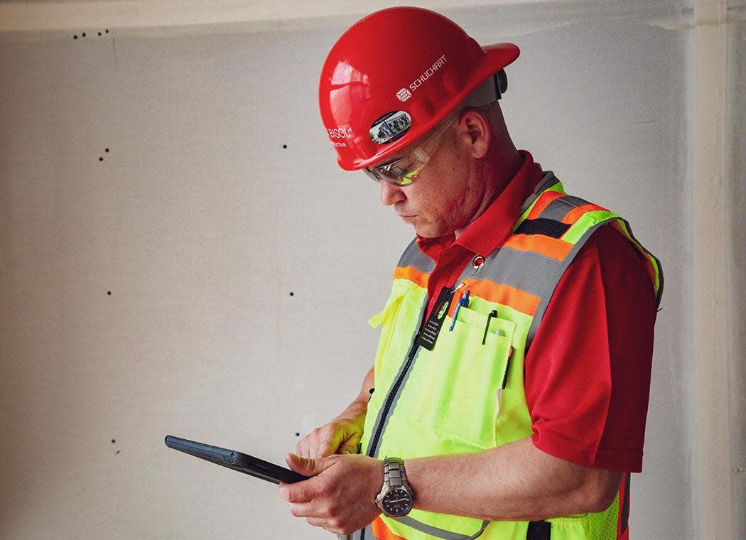 Contractor using Procore on a tablet