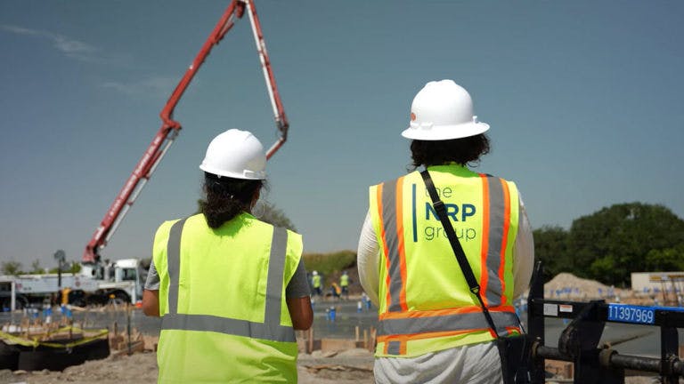 NRP group contractors looking at a construction site, seen from the back