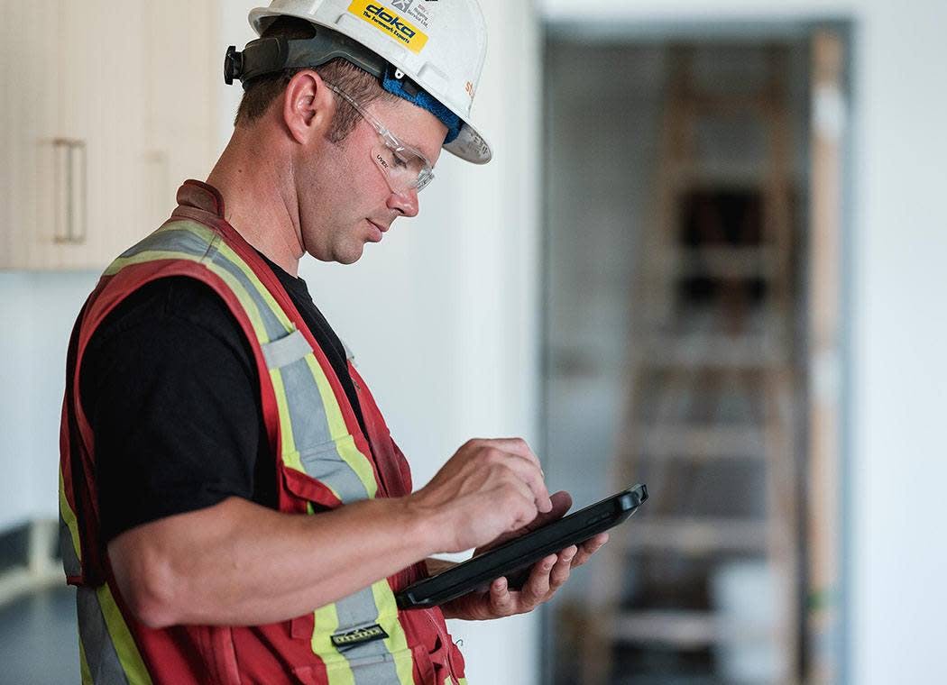 Contractor using Procore on a tablet