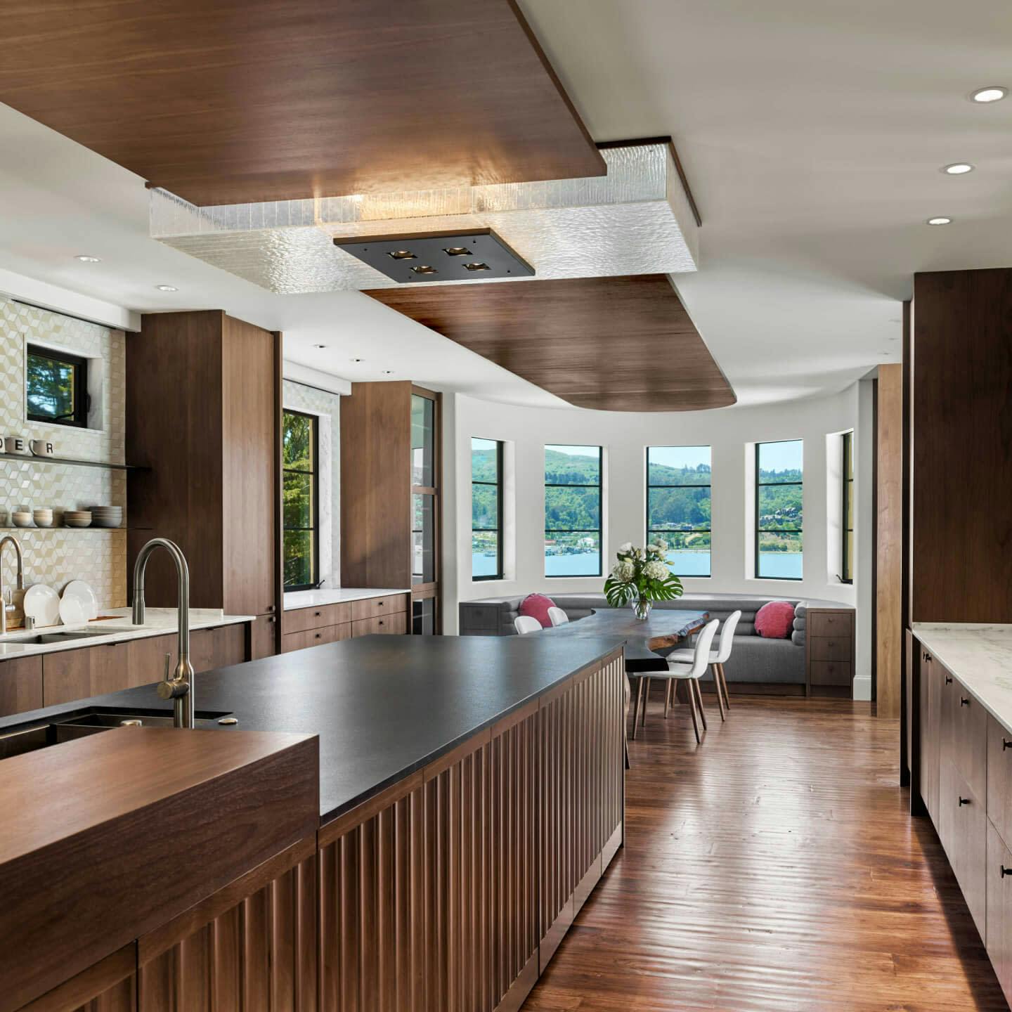 Photography of a home's kitchen and dining area with a view of a lake