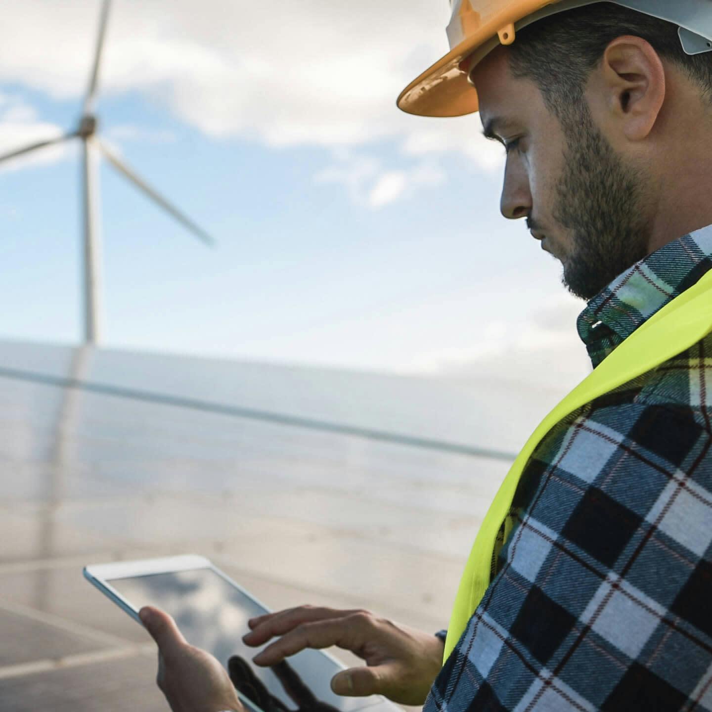 Construction worker using his tablet on a renewable energy farm
