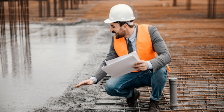 Worker on a jobsite performing a concrete takeoff