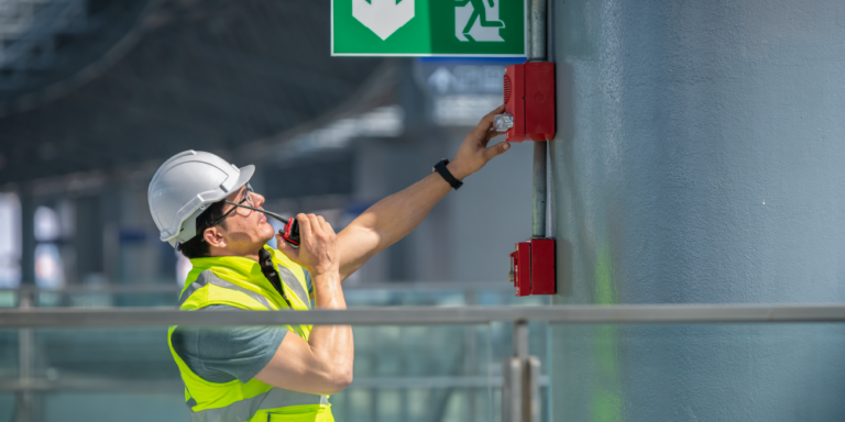 Photo of a construction worker checking an alarm in a fire sprinkler system