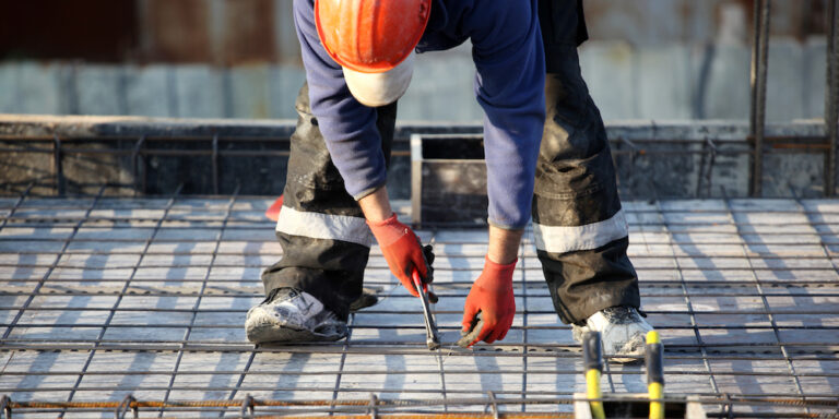 Photo of construction worker working in concrete