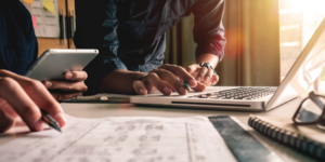 Up close photo of people on laptops — calculating profit markup vs margin