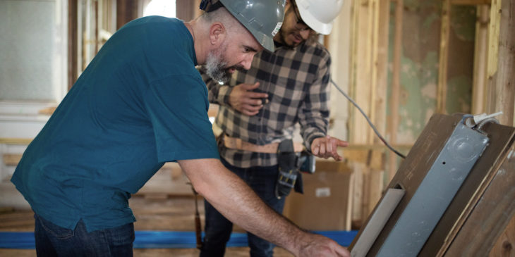 Photo of two construction workers looking at specs