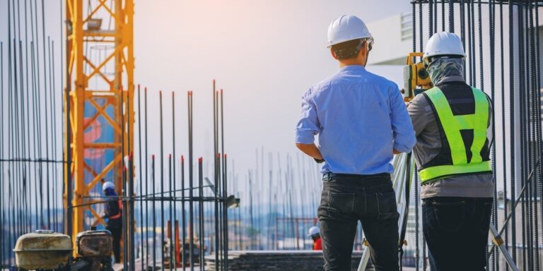 Engineer and surveyor surveying a commercial construction site