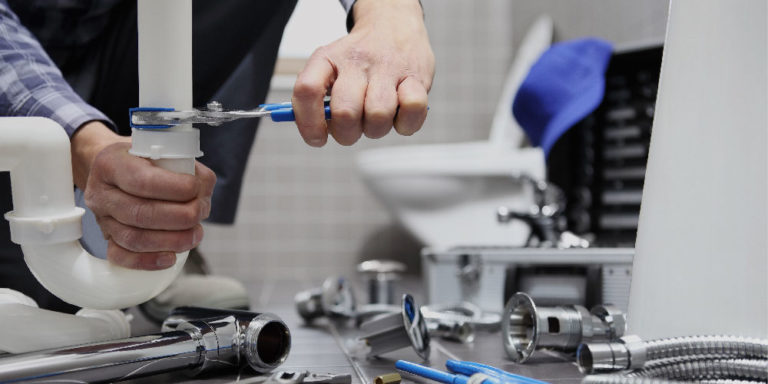 Close up of man's hands tightening a plumbing fixture.