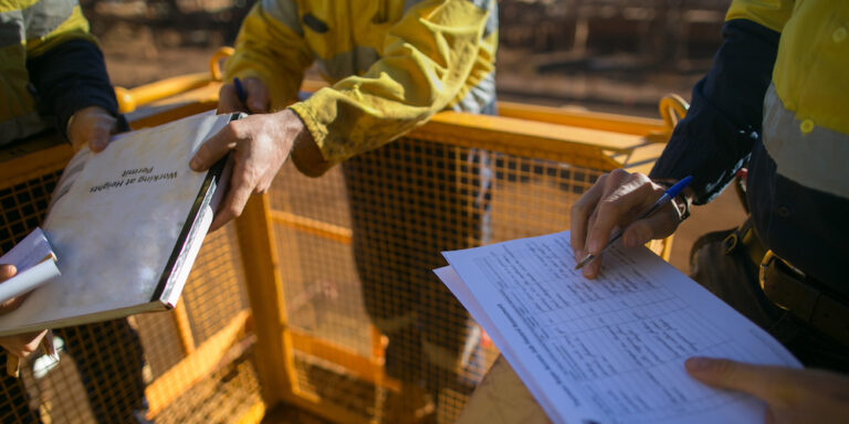Jobsite workers filling out a job safety analysis and hazard report