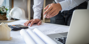 Photo of hand reviewing documents with calculator