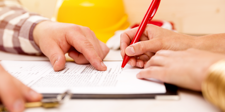 Photo of 2 people talking over and signing a document