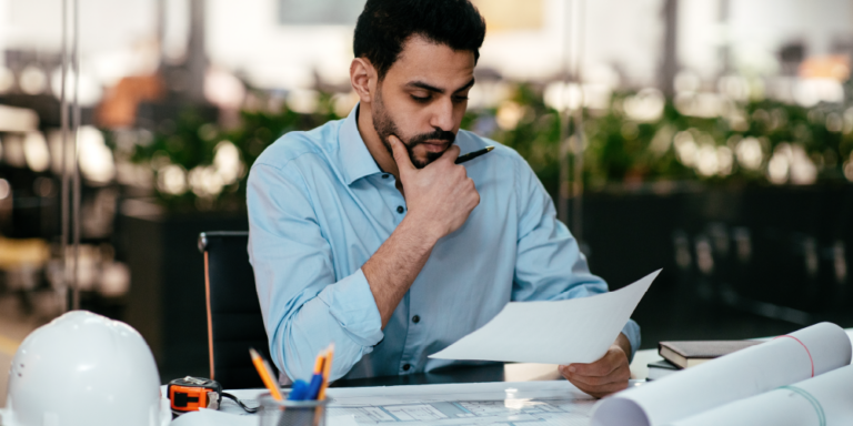 A man reviews construction drawings and other bid package documents