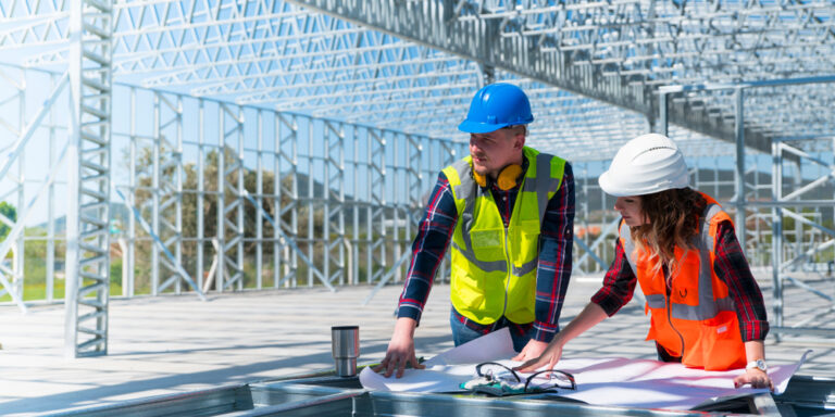 Construction manager and project manager review drawings on a commercial jobsite