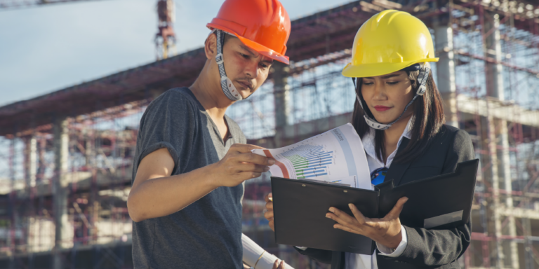 Photo of two people on a construction site reviewing paperwork