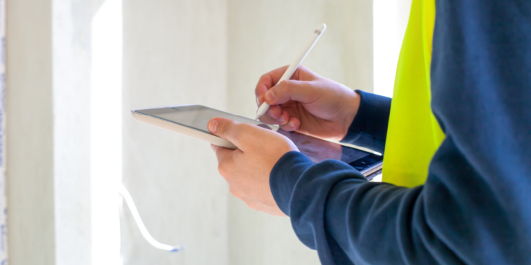 Photo of closeup of person peforming final building inspection with checklist on an electronic tablet