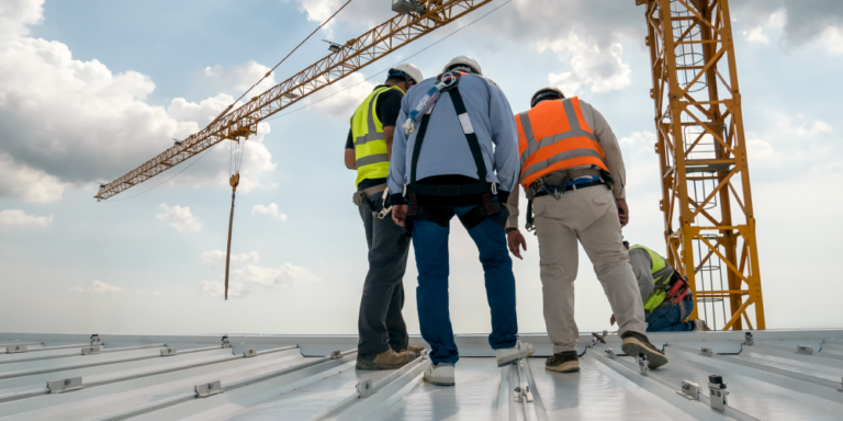Photo of 3 workers on a roof conducting a commercial roof inspection