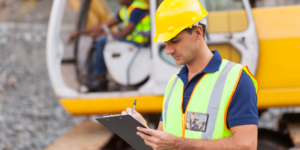 Photo of worker on a construction site filling out a construction field report