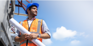 Construction professional looks into the distance while holding plans