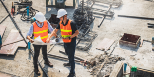 Photo of 2 workers reviewing paperwork at a jobsite