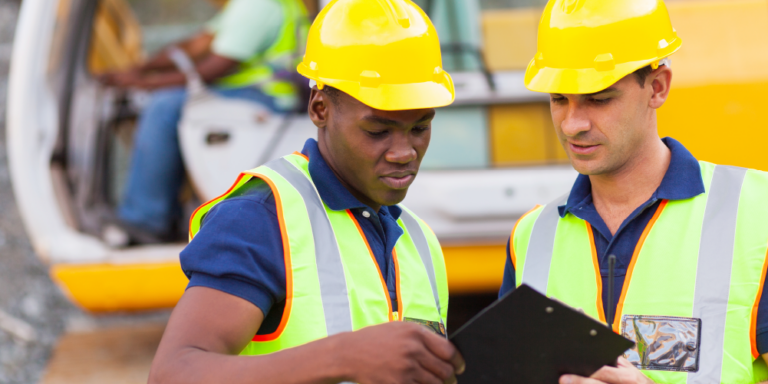 Two contractors review construction documents on a jobsite.