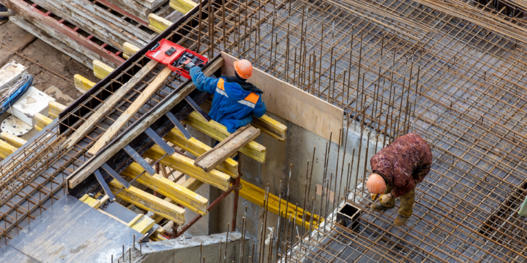 Photo of construction workers laying materials on a construction site