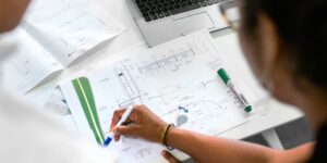 Two people review construction drawings and discuss project specifications.