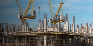 Two cranes tower stand tall above a construction site.