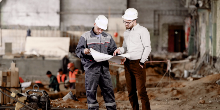 A superintendent and project manager looking at plans on a construction site