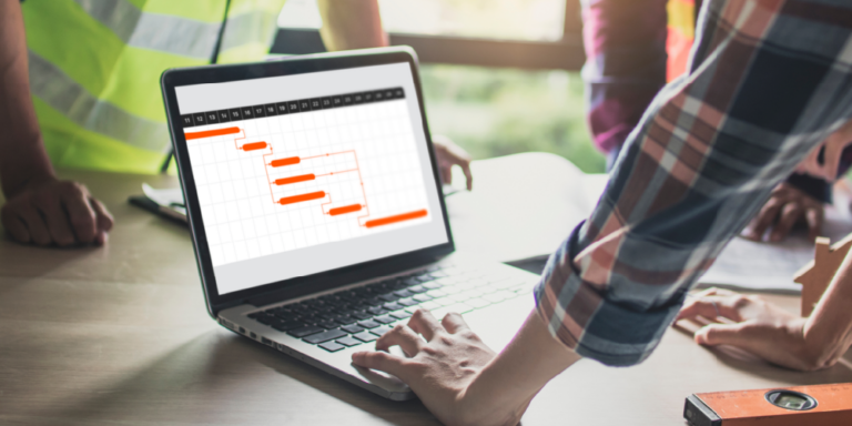 Photo of someone looking at a construction Gantt chart on a laptop computer.
