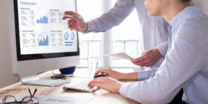 Photo of a professional looking at a cash flow report on a desktop computer