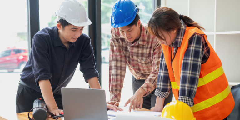 Photo of 3 construction professionals reviewing constrution cost reports