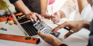 Photo of 2 people using a laptop and calculator