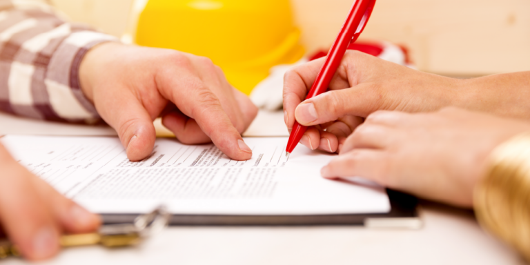 Photo of 2 people signing construction contract documents