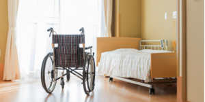 Photo of the inside of a senior living facility featuring a wheelchair and bed
