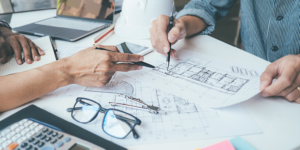 Closeup photo of 2 people looking over construction drawings