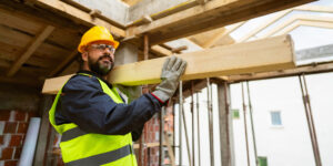 Roofer carrying a timber beam