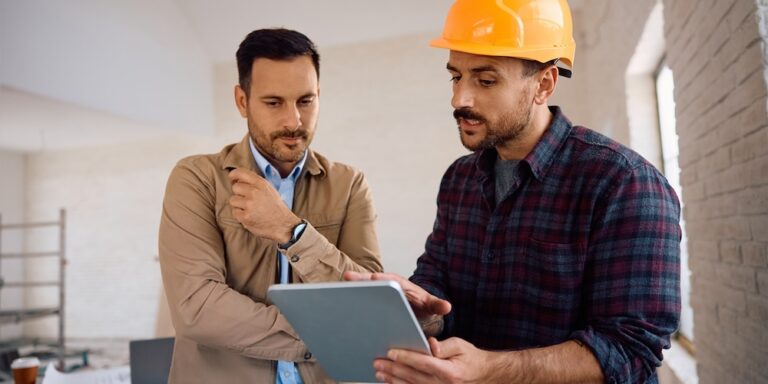 Two construction professionals reviewing an RFP on a tablet