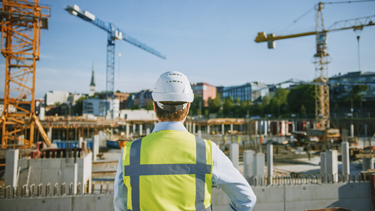 Construction worker surveying a commercial construction jobsite