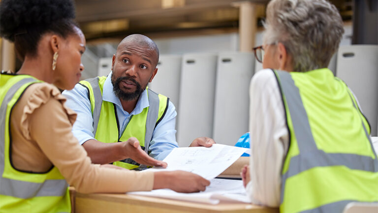 3 construction workers looking over construction documents