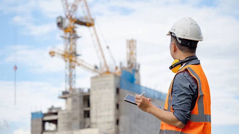 Construction worker on site looking at data on a tablet