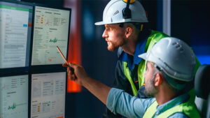 Construction pros reviewing data on multiple computers