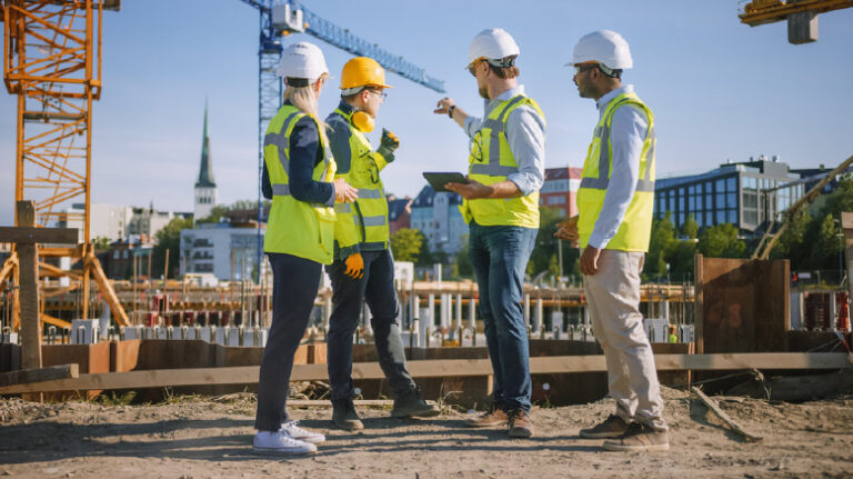4 construction workers discuss materials at a jobsite