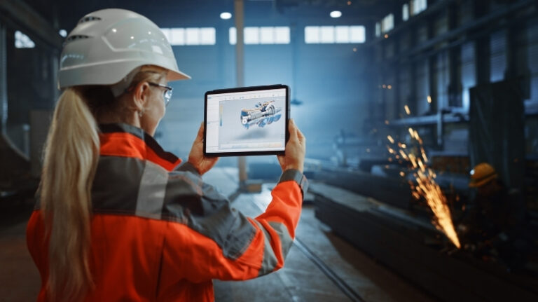 Construction worker surveying active work site with tablet