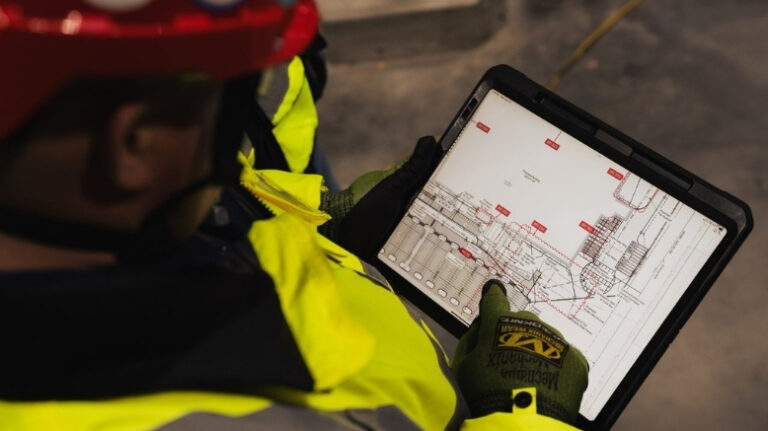 Contractor looking at project dashboard via a tablet while on a jobsite