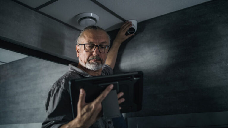Maintenance worker in a building checking a security camera