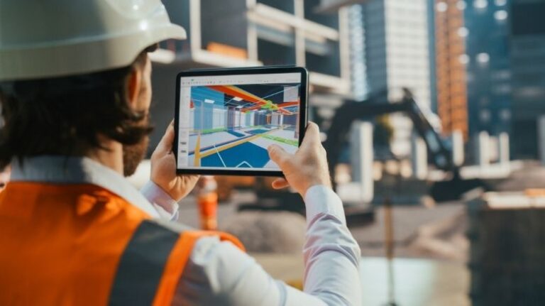 Construction professional holds a tablet comparing a BIM file to the actual jobsite.