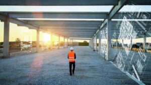 Photo of a worker walking across a construction site with superimposed AI construction drawings surrounding him